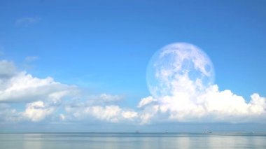 Süper Ay, denizin üstünde bulanık beyaz bulut.