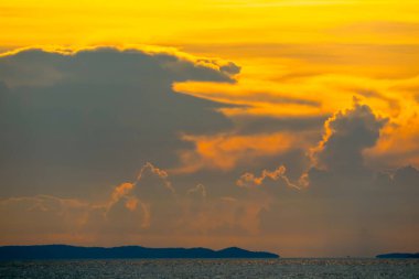 Günbatımı turuncu bulutu karanlık siluet gökyüzünde ve deniz arka planında gemi