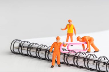 Herhangi bir sorun için toplu bir çözüm kavramı. Minyatür oyuncak işçiler bir ataş taşırlar. İşçiler Şef bertaraf gerçekleştirin. Yakın çekim görünümü.