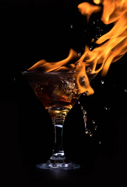 El concepto de bebida caliente con cubitos de hielo en un vaso. Sobre un fondo negro . — Foto de Stock