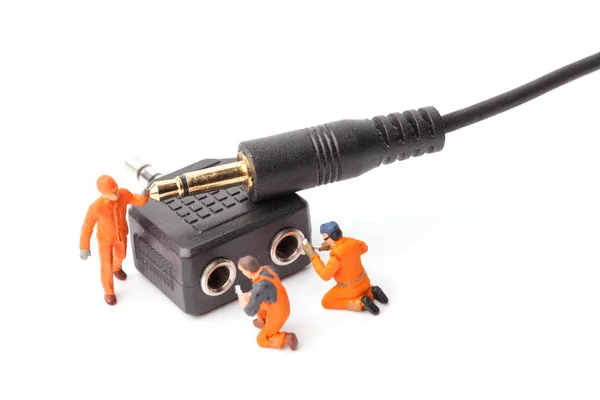 微型工人队正在做连接电缆耳机插座 — 图库照片