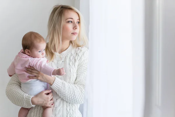 Mamma leker med barnet på ett fönster — Stockfoto