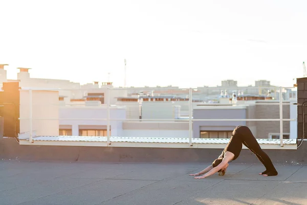 屋根の上のヨガを行う若い女性 — ストック写真