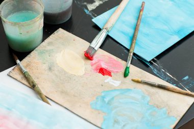 Boyalar ve fırçalar masaya vardır