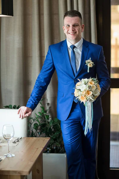 Groom ständiga och hålla bröllop bukett — Stockfoto