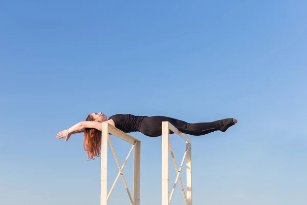 Jonge vrouw doet yoga op het dak — Stockfoto