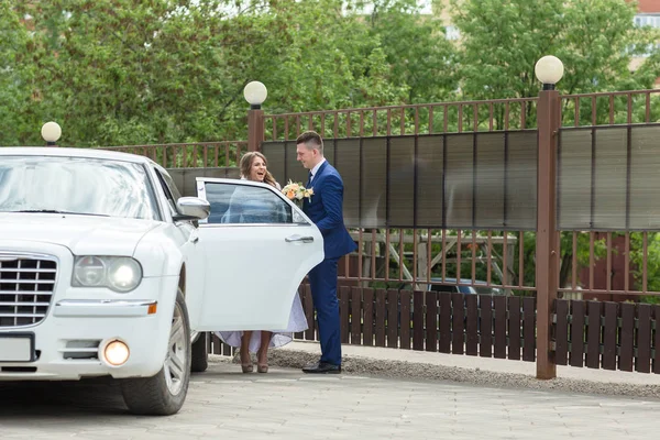 Жених и невеста идут к машине — стоковое фото