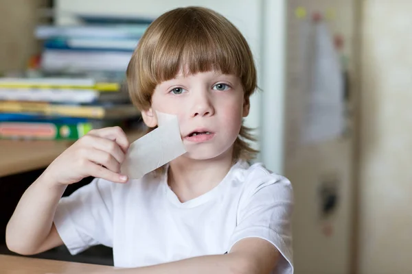 Child sits with mouth sealed tape — Stock Photo, Image