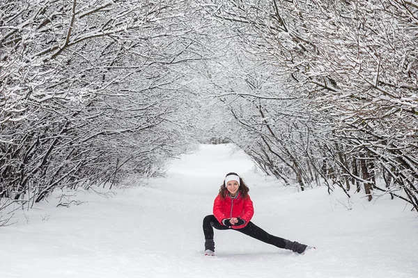 Mujer joven haciendo ejercicios de estiramiento durante el invierno — Foto de Stock