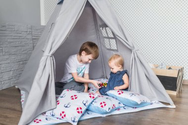 Bir teepee çadır ile oynayan çocuk