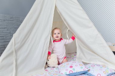 Bir teepee çadır ile oynayan çocuk