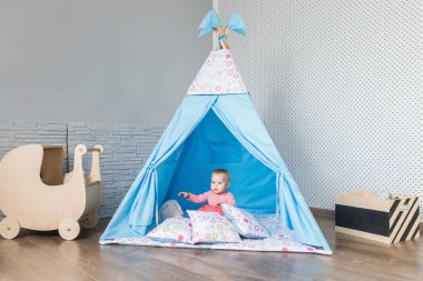 Bir teepee çadır ile oynayan çocuk