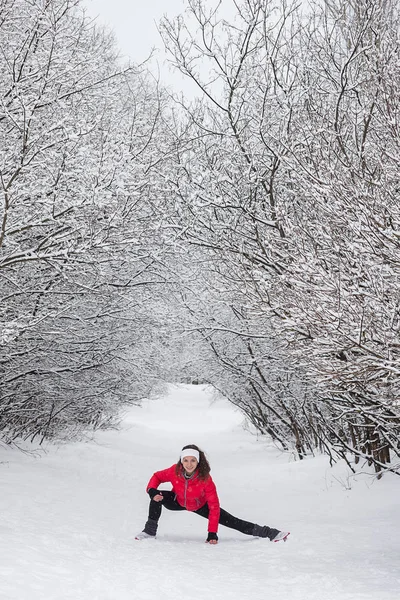 Mujer joven haciendo ejercicios de estiramiento durante el invierno — Foto de Stock