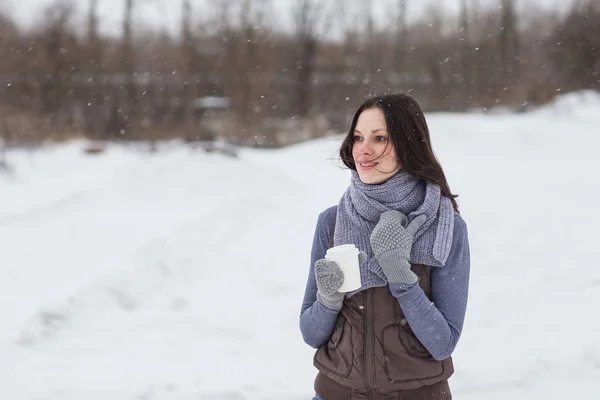 Woman holding hot drink outside — Stock Photo, Image