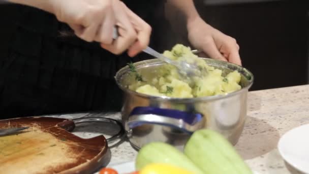 Женские руки смешивают вареный картофель — стоковое видео