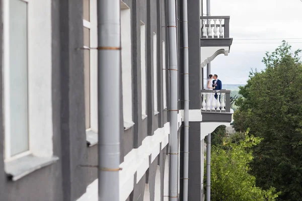 Свадебная пара, стоящая на балконе — стоковое фото