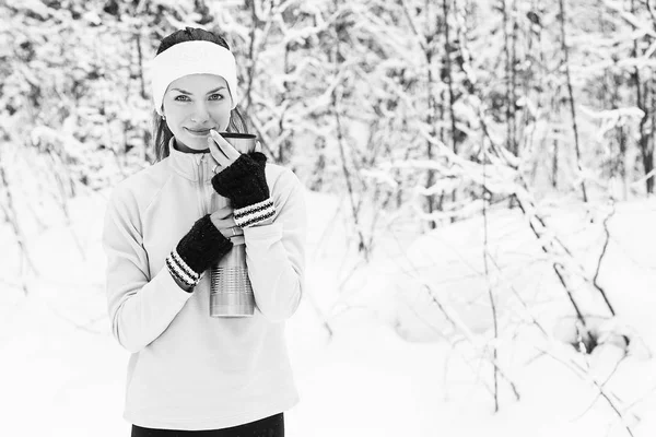 Kadın dökülen ve koşu sonra bir termos çay içiyor