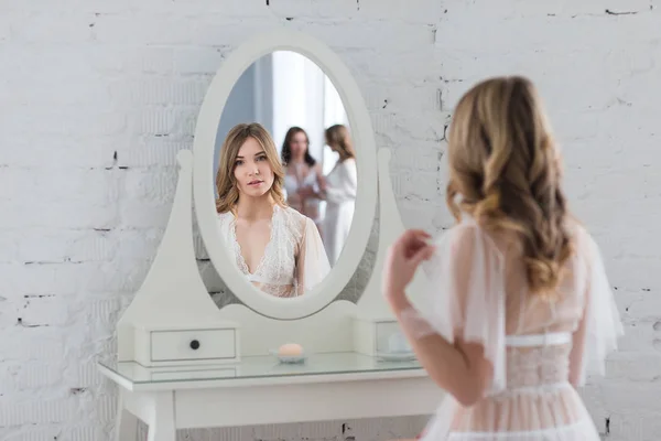 Нежная девушка в элегантном белье перед зеркалом — стоковое фото