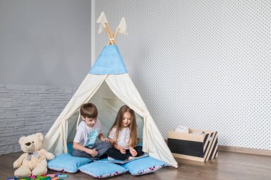Bir teepee çadır ile oynayan çocuk