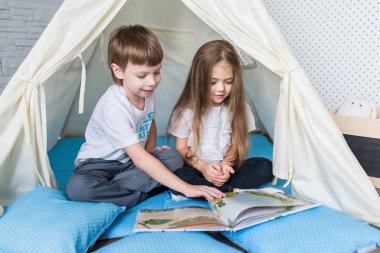 Bir teepee çadır ile oynayan çocuk