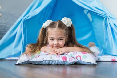 Bir teepee çadır ile oynayan çocuk