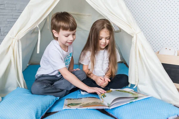 Bir teepee çadır ile oynayan çocuk