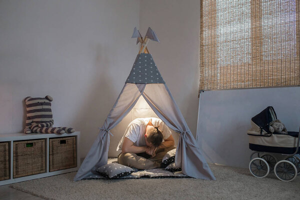 Отец расстроен и в отчаянии сидит в игровой комнате
