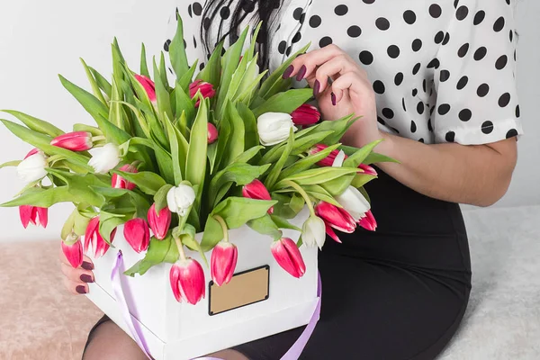 Mujer sosteniendo ramo de rosas y tulipanes en caja — Foto de Stock