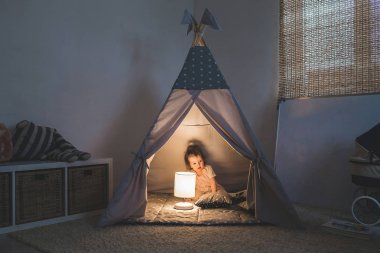Teepee içinde oynayan kız