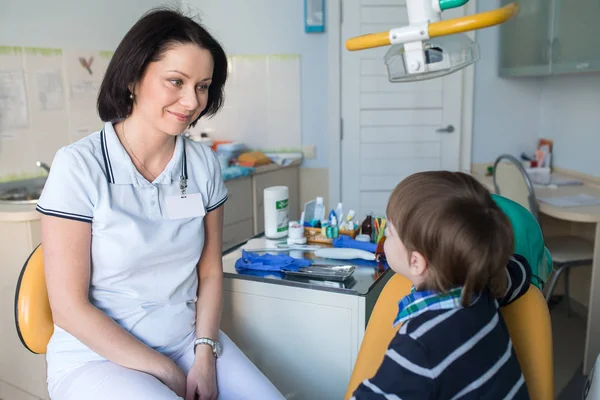 Happy female dentist with talking to child — Stock Photo, Image