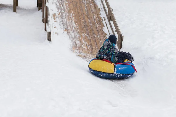 Bambino felice sta andando a montagna di ghiaccio per tubi in inverno — Foto Stock