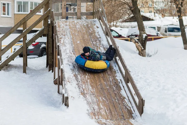 Criança feliz está indo para a montanha de gelo para tubulação no inverno — Fotografia de Stock