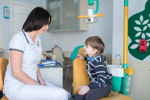 Dentista mujer feliz con hablar con el niño — Foto de Stock
