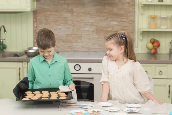 Słodkie dzieci pieczone ciasteczka i degustacja to przy stole w kuchni — Zdjęcie stockowe