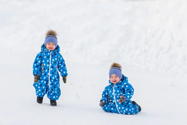 Kışın parkta yürüyüş ikiz erkek, ilk adımlarını öğrenmek — Stok fotoğraf