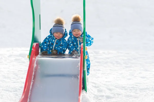 Zwillingsjungen laufen im Winter im Park und rollen mit eiserner Rüstung — Stockfoto