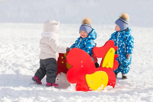 Crianças irmãos gêmeos andando no inverno com brincando com outras crianças — Fotografia de Stock