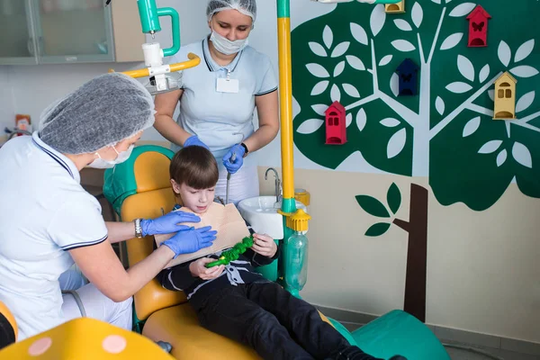 Dentista y enfermera curando dientes infantiles — Foto de Stock