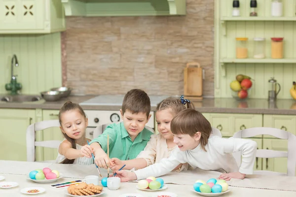 Húsvét napján. Egy csapat gyerek festeni a húsvéti tojás és a nevetés. — Stock Fotó