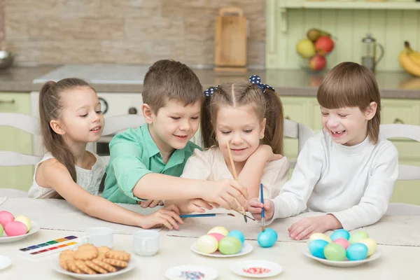 Dzień Wielkanocy. Grupa dzieci malowanie pisanek i śmiać się. — Zdjęcie stockowe