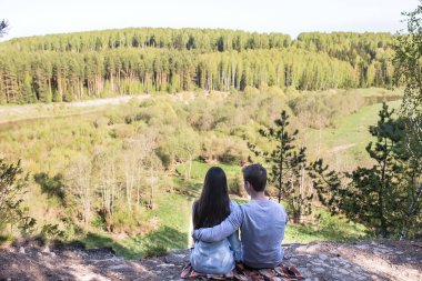 Bir uçurumun kenarında oturan genç Çift