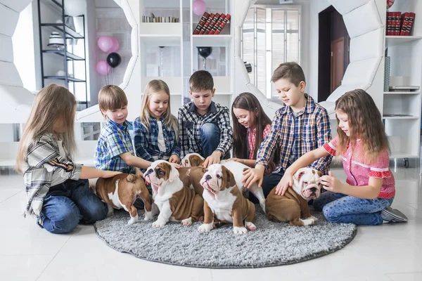 Portrait of little children with cute puppies on the floor at home — Stock Photo, Image