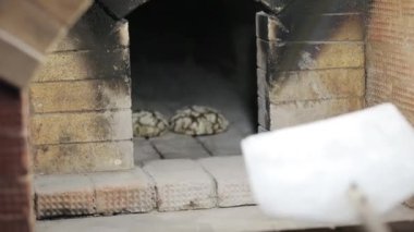 Önlük erkek Baker fırından yeni çıkmış iki somun ekmek alır.