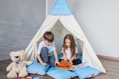 Bir teepee çadır ile oynayan çocuk