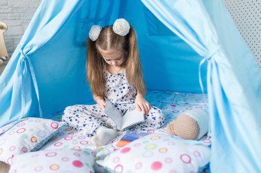 Bir teepee çadır ile oynayan çocuk