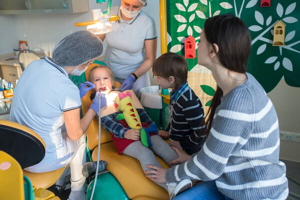 ребенок с матерью в кабинете дантиста
