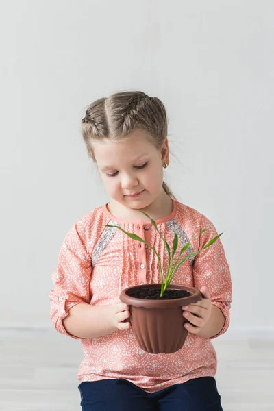 Het kind helpt de plant om te groeien, het begrip milieu — Stockfoto