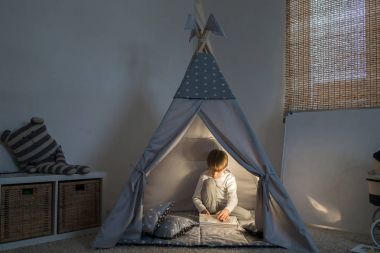 Teepee içinde oynayan çocuk