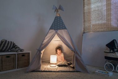 Teepee içinde oynayan kız
