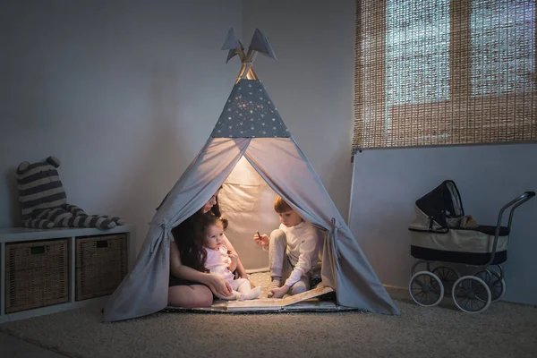 Madre lee libro en un tipi — Foto de Stock